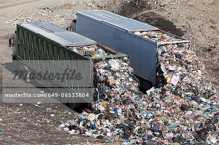 Trucks dumping waste in landfill