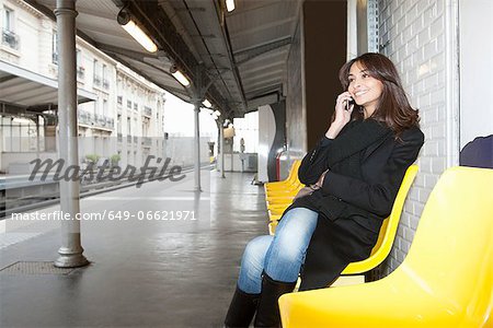 Woman on cell phone at train station