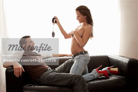 Woman stripping for boyfriend on sofa