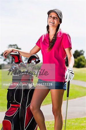 Woman holding golf bag on course