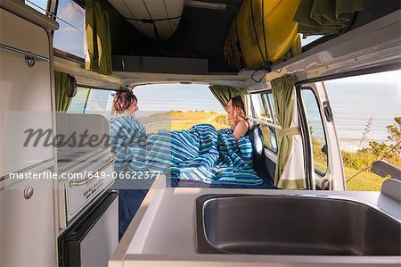 Couple under comforter in trailer