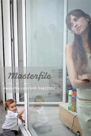 Boy watching mother look out window