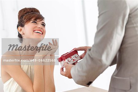 Man giving smiling girlfriend present
