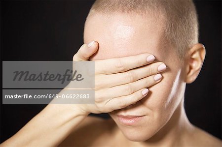 Nude woman covering her eyes
