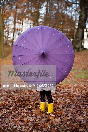 Girl playing with umbrella in park