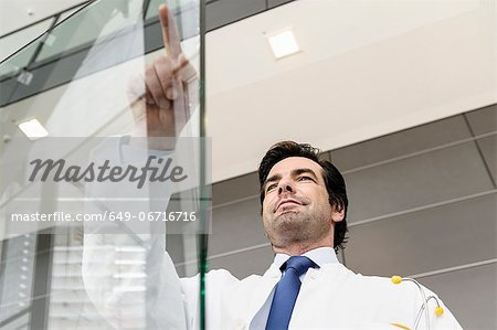 Doctor pointing to glass panel