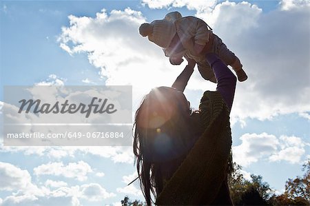 Mother playing with baby girl outdoors