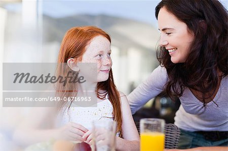 Mother smiling at daughter at breakfast