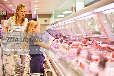 Mother and daughter at butcher counter