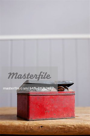 Antique tin full of money on desk Antique tin full of money on desk