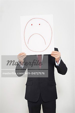 Businessman holding sad face over his face