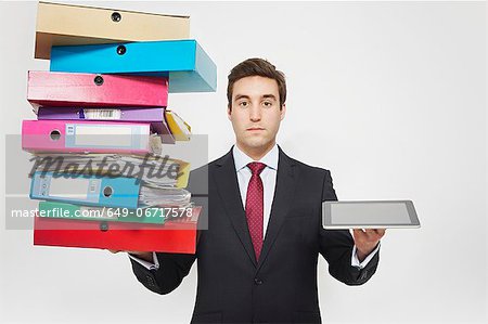 Businessman with stacks of folders and tablet computer Businessman with stacks of folders and tablet computer