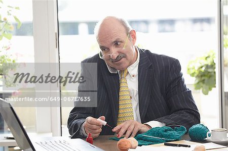 Businessman painting his nails at desk