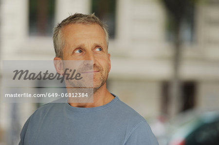 Mature man looking away and smiling, indoors