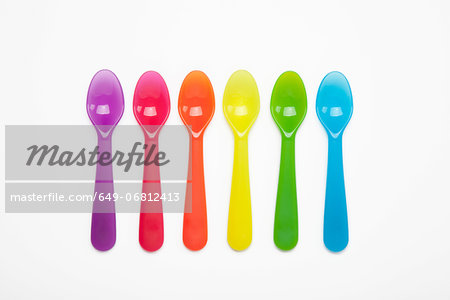 Colourful plastic spoons in a row
