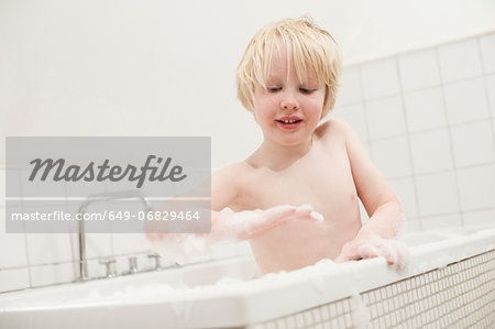 Boy looking at soapsuds in the bathtub