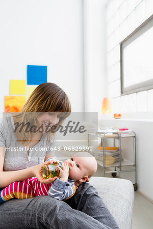 Mother feeding baby son with bottle