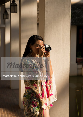 Woman taking photograph by columns in hotel