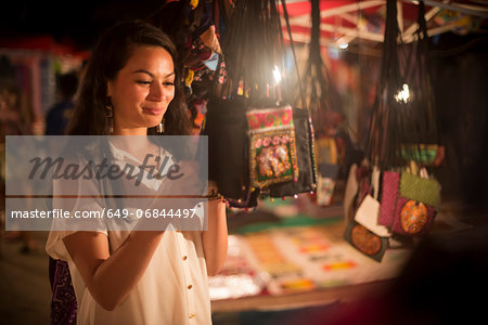 Woman looking at handbags in night market, Luang Prabang, Laos