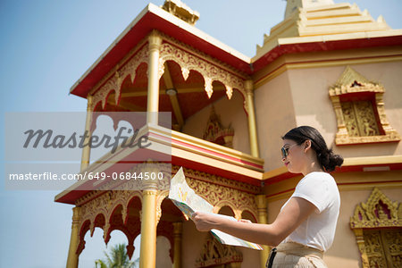 Woman outside building with map, Luang Prabang, Laos