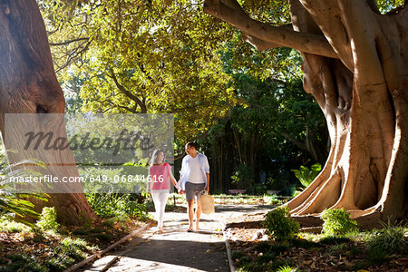 Young couple walking on path through trees