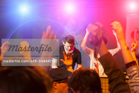 Disc jockey surrounded by raised arms Disc jockey surrounded by raised arms