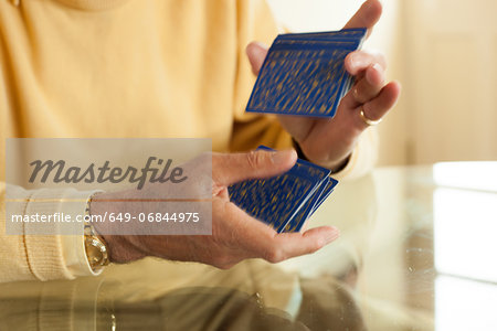 Close up of aged hands shuffling playing cards