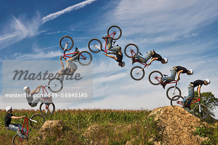 Man performing stunt on bmx bike, digital composite