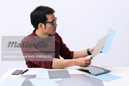 Young male designer looking at color swatch samples