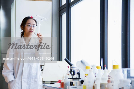 Female scientist examining glass tubes