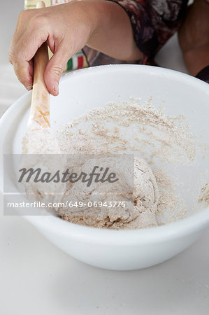 Close up of boy stirring dough in bowl