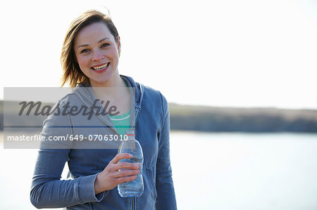 Portrait of young woman at coast taking exercise break