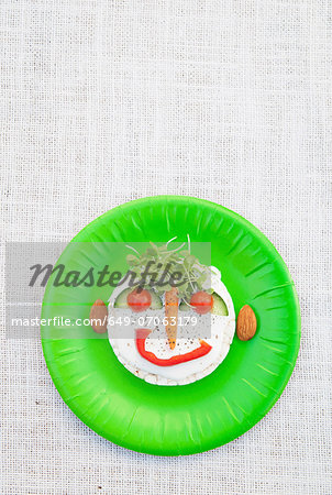 Face made from fresh food on green plate