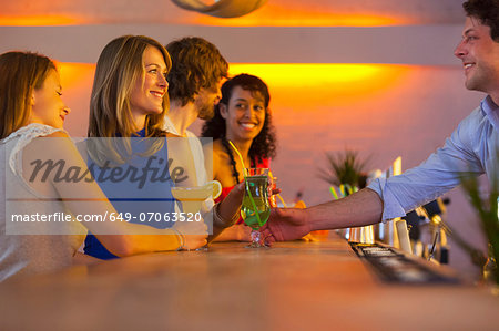 Group of friends ordering cocktails in bar