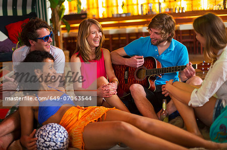 Friends enjoying guitar playing in bar