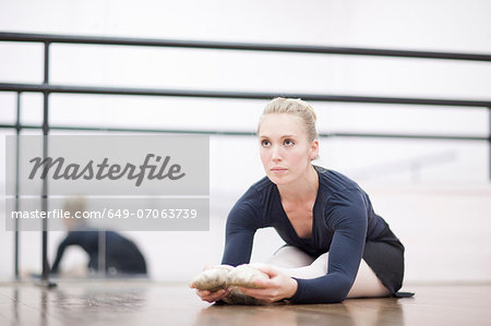 Female ballerina stretching on the floor