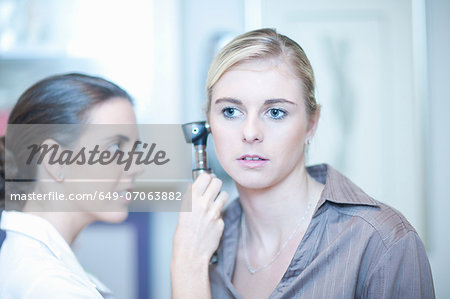 Patient having ear examined by doctor