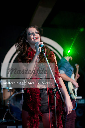 Young female singing on stage in club