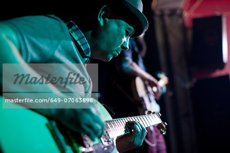 Man playing guitar on stage in nightclub Man playing guitar on stage in nightclub