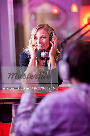 Young man and woman broadcasting in recording studio