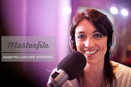 Mid adult woman broadcasting in recording studio, portrait Mid adult woman broadcasting in recording studio, portrait