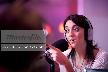 Mid adult woman broadcasting in recording studio Mid adult woman broadcasting in recording studio