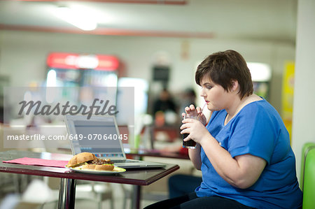 Young woman drinking coke in cafe Young woman drinking coke in cafe