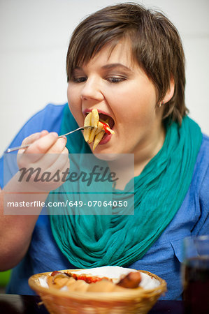 Young woman in cafe eating fries
