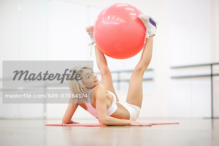 Young woman stretching with exercise ball