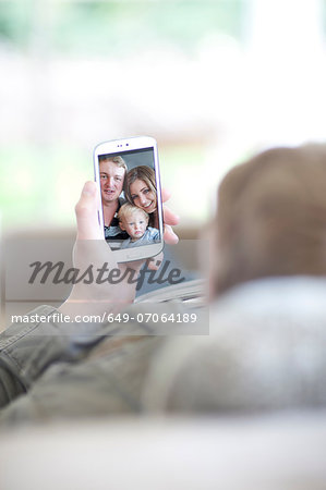 Man looking at family photo on cellphone