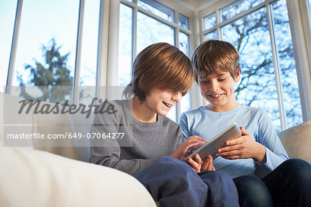 Brothers using digital tablet together