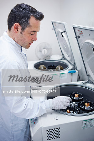 Man putting vials into centrifuge