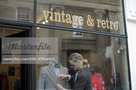 Woman putting jacket on shop dummy