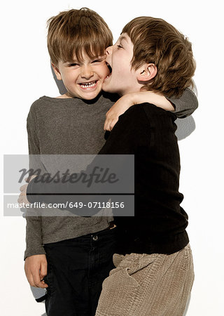 Boy biting brother's cheek